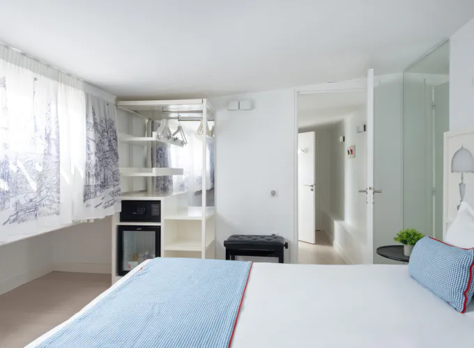 Chambre Duplex à l’Hôtel 34B avec literie confortable et décoration aux tons bleus et blancs.