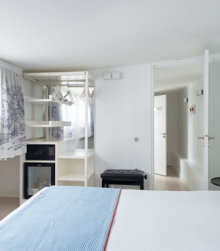 Chambre Duplex à l’Hôtel 34B avec literie confortable et décoration aux tons bleus et blancs.