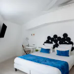 Chambre Familiale avec un lit et un bureau à l’Hôtel 34B