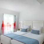 Chambre Familiale avec deux lits et des oreillers bleus à l’Hôtel 34B