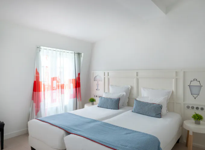 Chambre Familiale avec deux lits et des oreillers bleus à l’Hôtel 34B