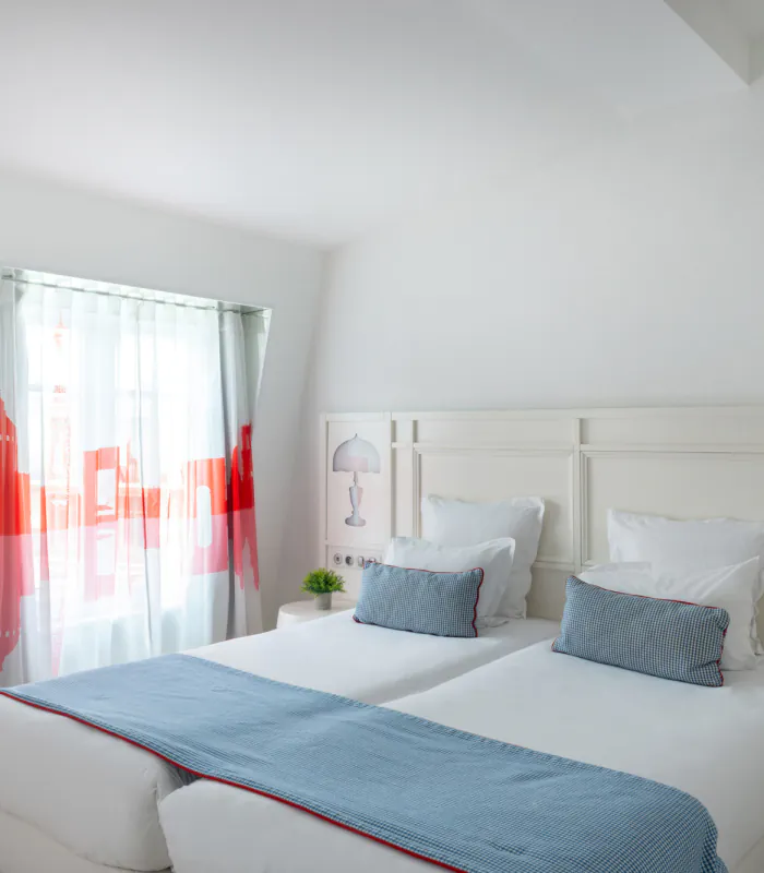 Chambre Familiale avec deux lits et des oreillers bleus à l’Hôtel 34B