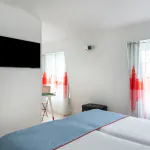 Chambre Familiale avec deux lits et des oreillers bleus à l’Hôtel 34B
