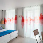 Chambre Twin Supérieure à l’Hôtel 34B avec deux lits simples et une décoration aux tons bleus, blancs et rouges.