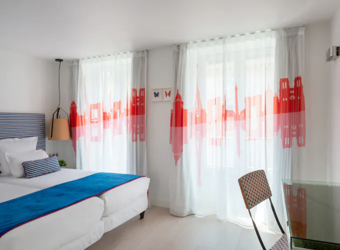 Chambre Twin Supérieure à l’Hôtel 34B avec deux lits simples et une décoration aux tons bleus, blancs et rouges.