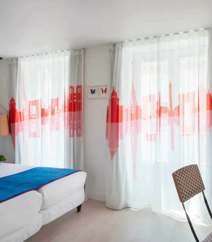 Chambre Twin Supérieure à l’Hôtel 34B avec deux lits simples et une décoration aux tons bleus, blancs et rouges.