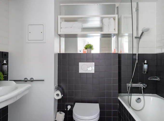 Salle de bain de la Chambre Twin Supérieure avec des carreaux noirs et blancs et un lavabo à l’Hôtel 34B
