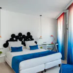 Chambre Familiale Supérieure avec un grand lit et des rideaux bleus à l’Hôtel 34B