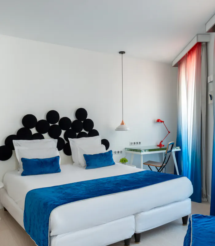 Chambre Familiale Supérieure avec un grand lit et des rideaux bleus à l’Hôtel 34B
