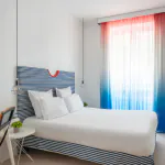 Chambre double avec tête de lit à rayures bleues et blanches à l’Hôtel 34B