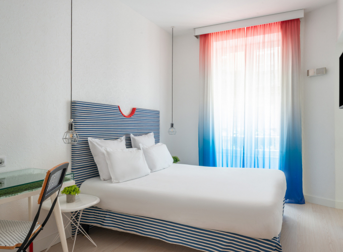 Chambre double avec tête de lit à rayures bleues et blanches à l’Hôtel 34B