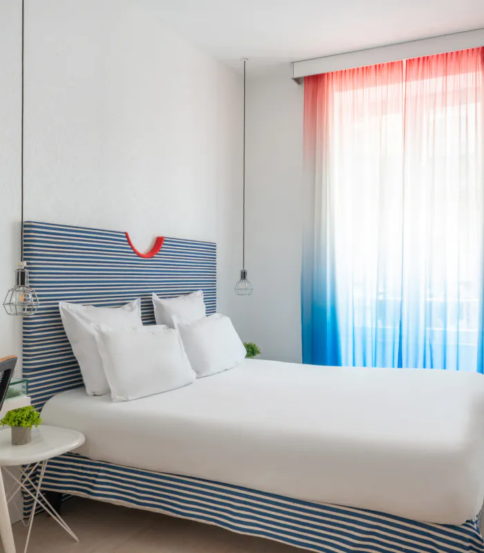 Chambre double avec tête de lit à rayures bleues et blanches à l’Hôtel 34B