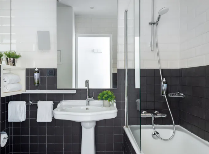 Salle de bain de la Chambre Familiale Supérieure avec des carreaux noirs et blancs et un lavabo à l’Hôtel 34B