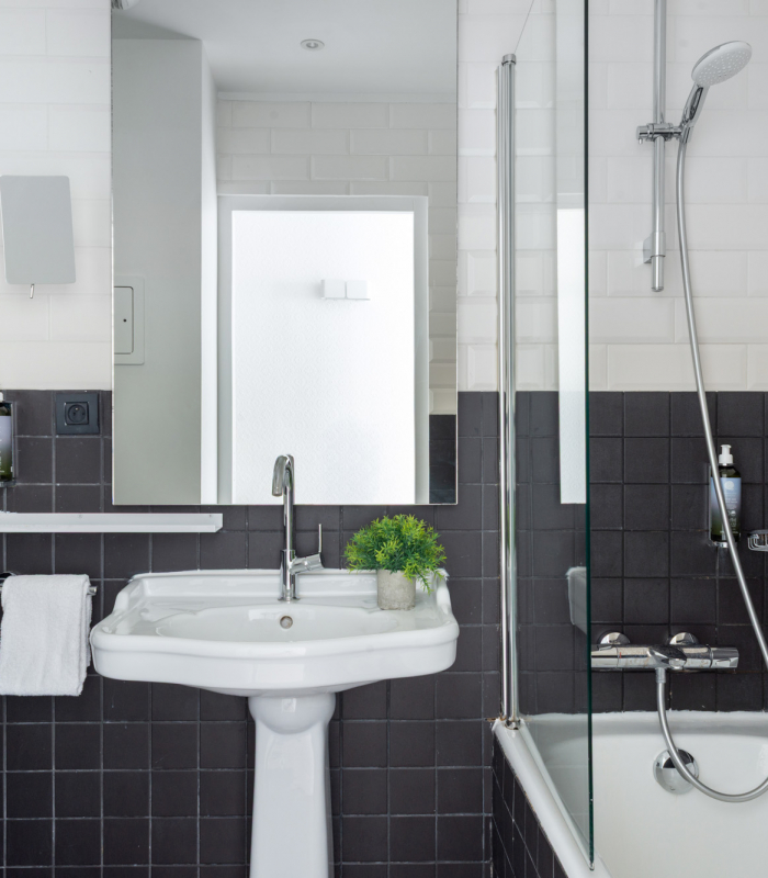 Salle de bain de la Chambre Familiale Supérieure avec des carreaux noirs et blancs et un lavabo à l’Hôtel 34B