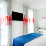 Chambre Familiale Supérieure avec une tête de lit rayée bleue et blanche à l’Hôtel 34B