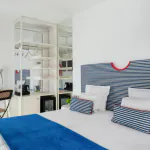 Chambre Familiale Supérieure avec une tête de lit rayée bleue et blanche à l’Hôtel 34B