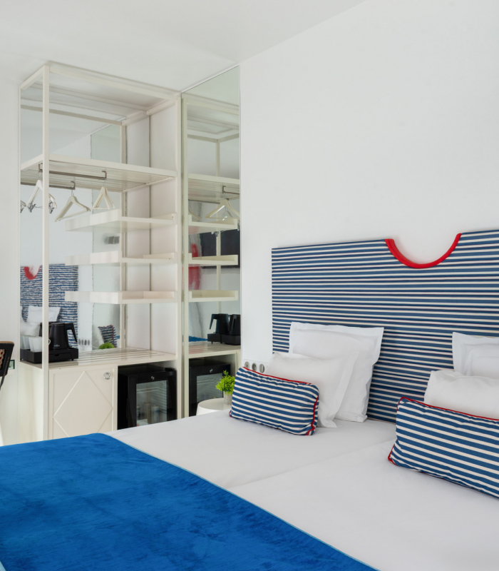 Chambre Familiale Supérieure avec une tête de lit rayée bleue et blanche à l’Hôtel 34B