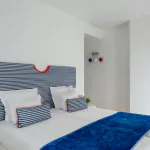 Chambre Familiale Supérieure avec une tête de lit rayée bleue et blanche à l’Hôtel 34B