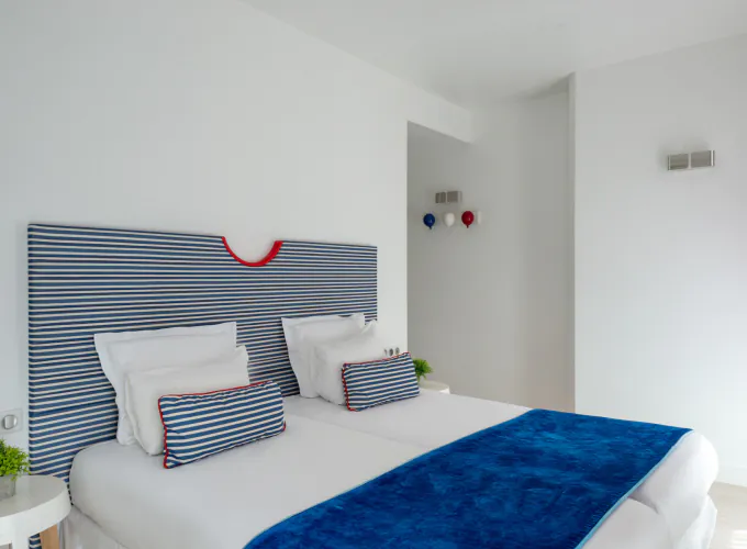 Chambre Familiale Supérieure avec une tête de lit rayée bleue et blanche à l’Hôtel 34B