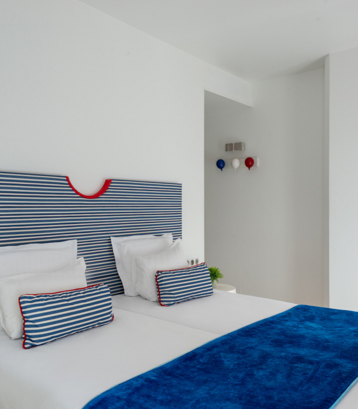 Chambre Familiale Supérieure avec une tête de lit rayée bleue et blanche à l’Hôtel 34B