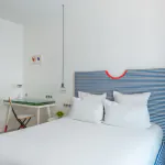 Chambre double avec tête de lit à rayures bleues et blanches à l’Hôtel 34B