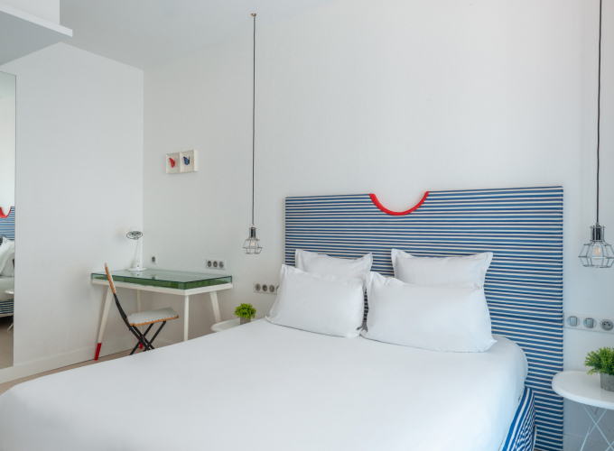 Chambre double avec tête de lit à rayures bleues et blanches à l’Hôtel 34B