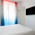 Chambre double avec tête de lit à rayures bleues et blanches à l’Hôtel 34B