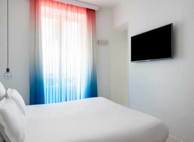 Chambre double avec tête de lit à rayures bleues et blanches à l’Hôtel 34B
