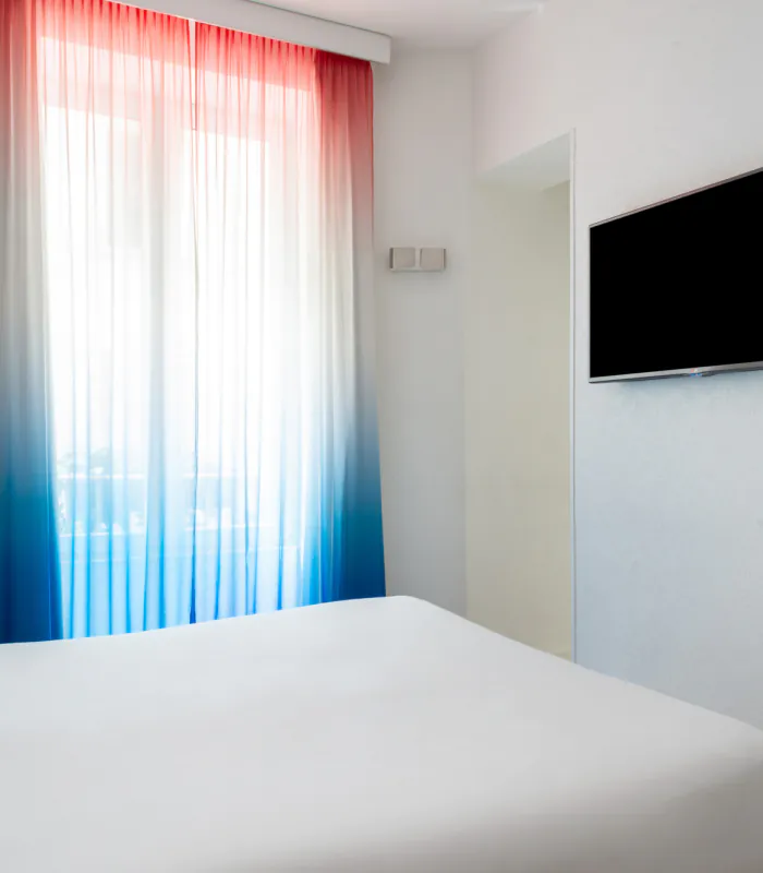 Chambre double avec tête de lit à rayures bleues et blanches à l’Hôtel 34B