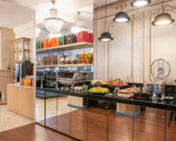 Breakfast buffet at the Malte Hotel Paris with pastries, breads, cheeses, cold meats and drinks