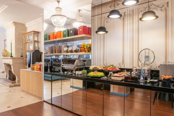 Breakfast buffet at the Malte Hotel Paris with pastries, breads, cheeses, cold meats and drinks