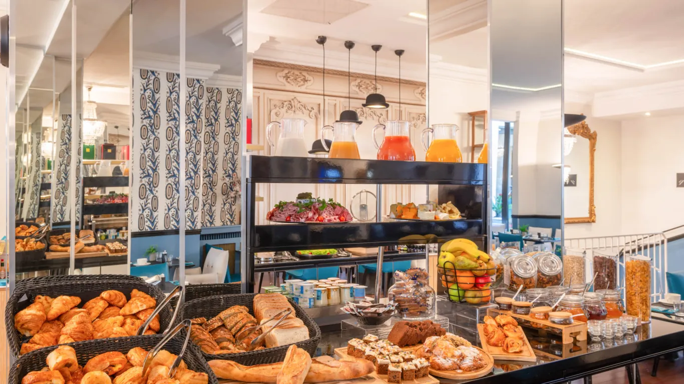 Breakfast buffet at the Malte Hotel Paris with pastries, breads, cheeses, cold meats and drinks