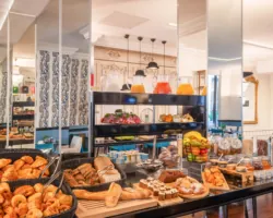 Breakfast buffet at the Malte Hotel Paris with pastries, breads, cheeses, cold meats and drinks