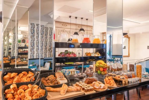 Breakfast buffet at the Malte Hotel Paris with pastries, breads, cheeses, cold meats and drinks