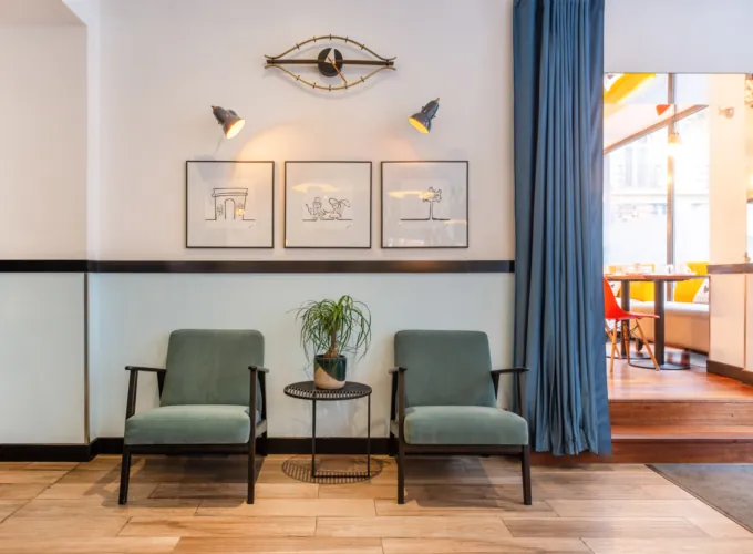 Vue du lobby de l’hôtel 3 étoiles Augustin à Paris, où des couleurs élégantes se marient parfaitement à une atmosphère raffinée