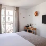 Chambre Double Balcon avec vue sur la Tour Eiffel à l’hôtel Palm disposant d’un bureau et d’une télévision