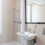 Salle de bain avec lavabo et douche de la Chambre Double Balcon Tour Eiffel à l’hôtel Palm