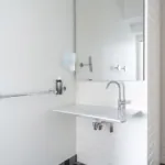 ホテル34bの鏡と手すり付きバリアフリー洗面台