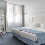 chambre twin accessible avec deux lits simples et décoration bleu clair à l’hôtel 34b