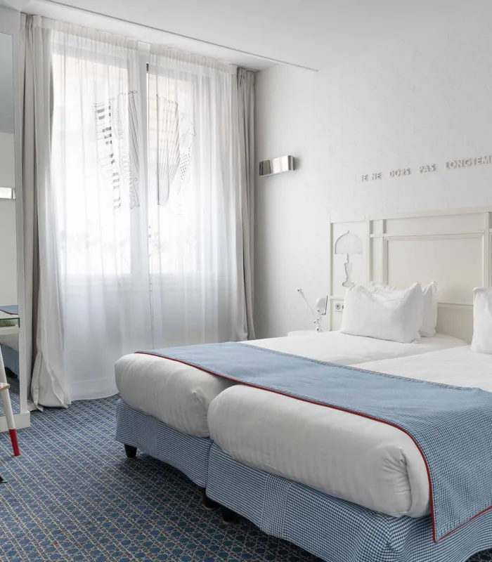 chambre twin accessible avec deux lits simples et décoration bleu clair à l’hôtel 34b