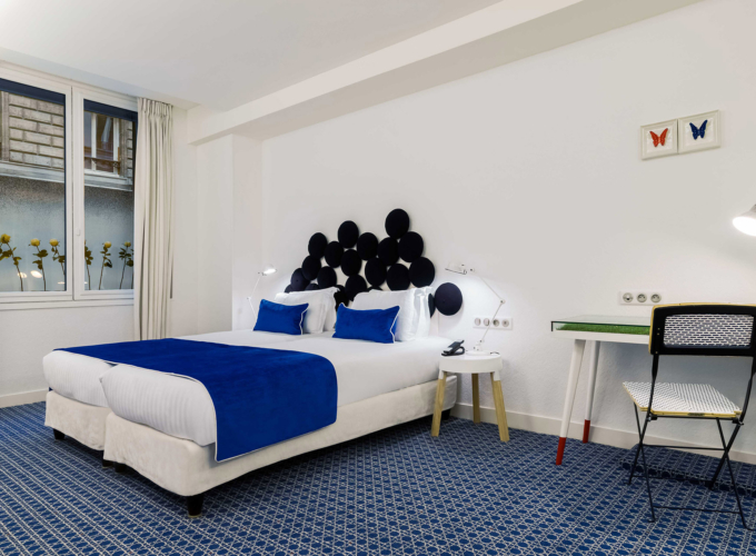 chambre twin accessible avec une tête de lit bleue et blanche à l’hôtel 34b