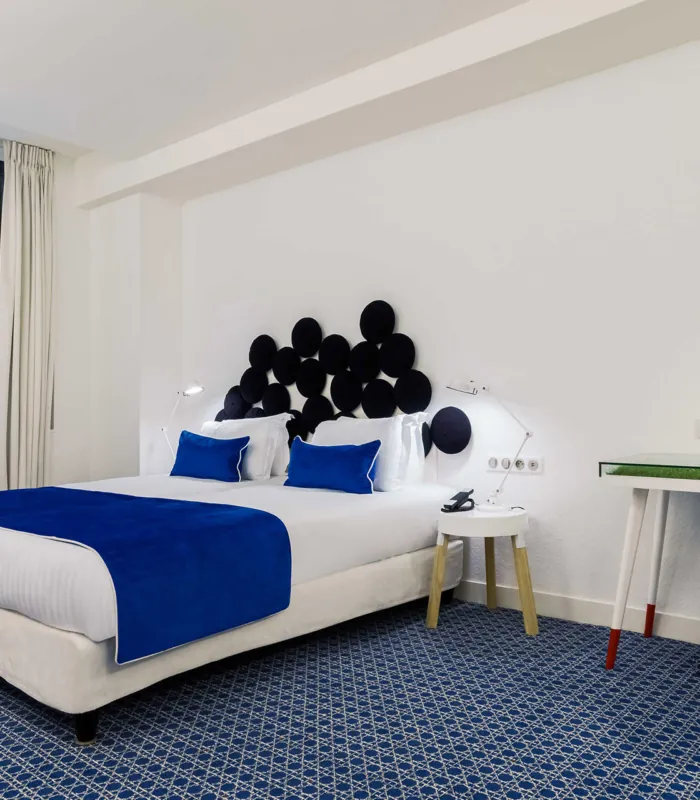 chambre twin accessible avec une tête de lit bleue et blanche à l’hôtel 34b