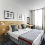 chambre twin accessible avec tête de lit en bois à l’hôtel lorette