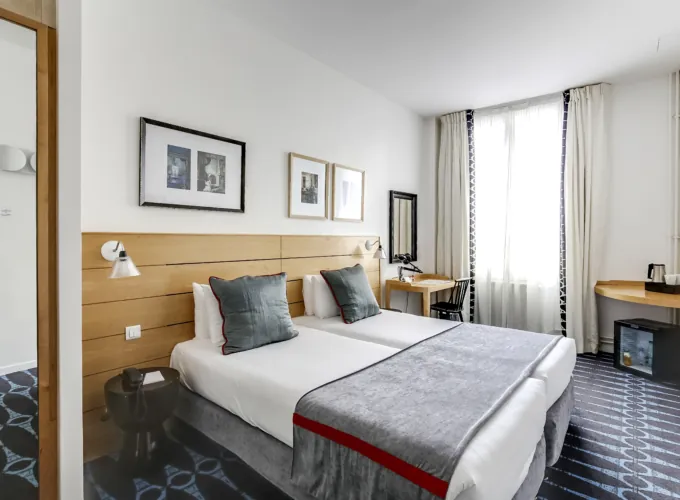 chambre twin accessible avec tête de lit en bois à l’hôtel lorette