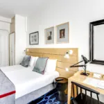 chambre twin accessible avec tête de lit en bois à l’hôtel lorette