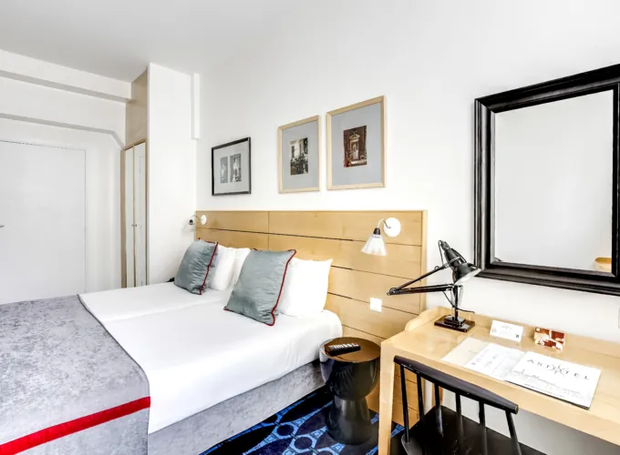 chambre twin accessible avec tête de lit en bois à l’hôtel lorette