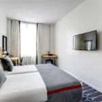 chambre twin accessible avec tête de lit en bois à l’hôtel lorette