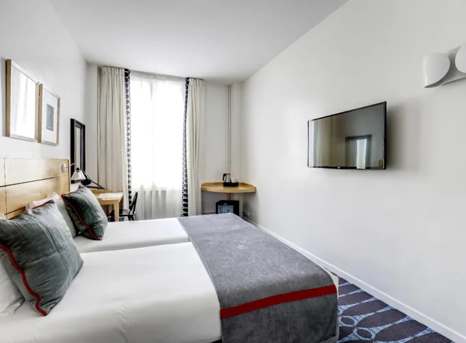 chambre twin accessible avec tête de lit en bois à l’hôtel lorette