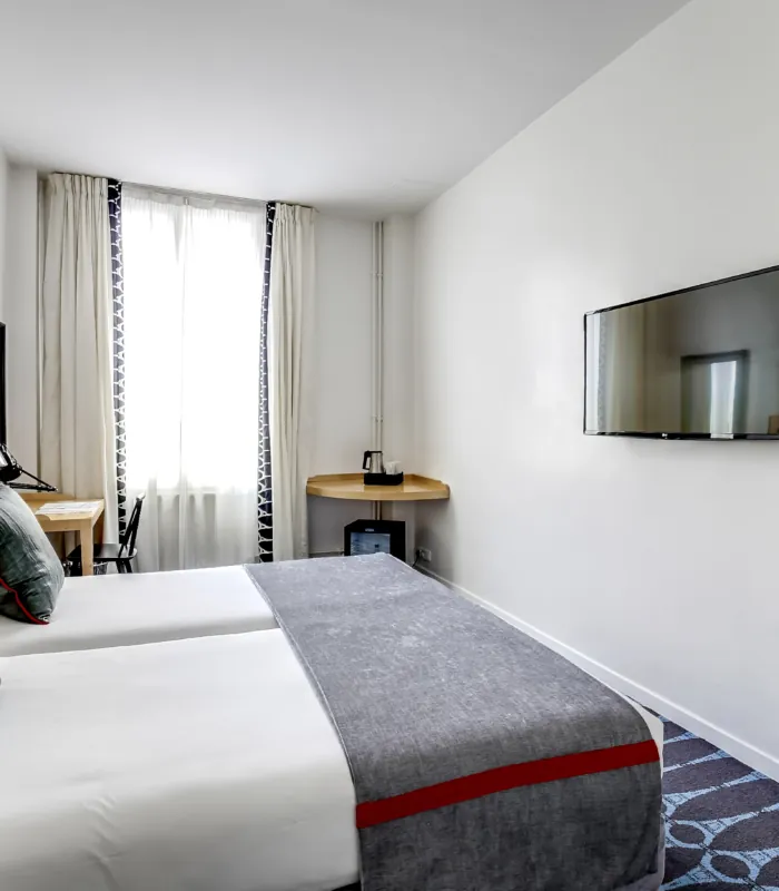 chambre twin accessible avec tête de lit en bois à l’hôtel lorette