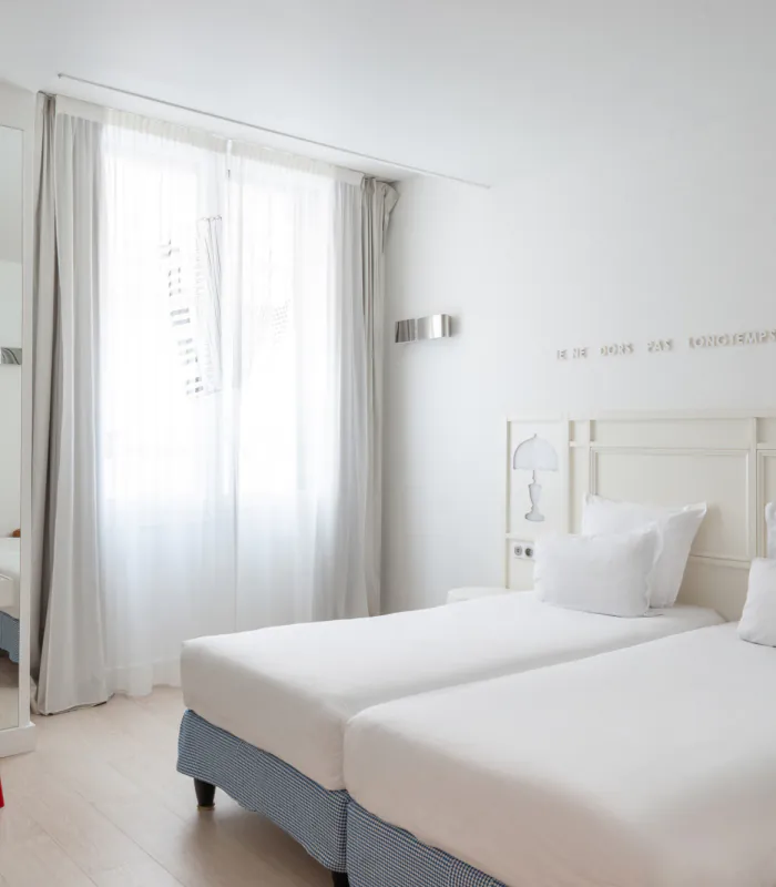 chambre twin accessible avec deux lits simples et décoration bleu clair à l’hôtel 34b